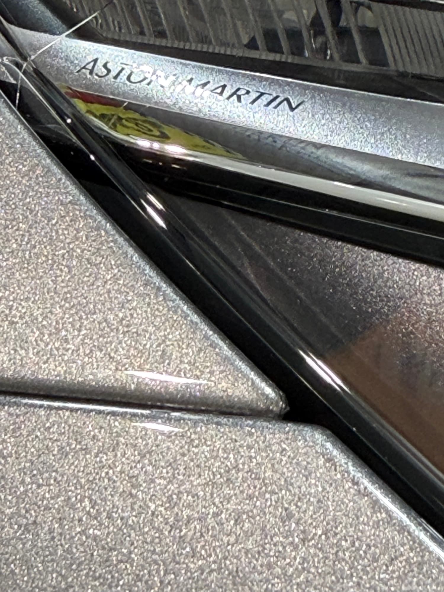 Aston Martin badge close-up — metallic flake clarity after Feynlab ceramic