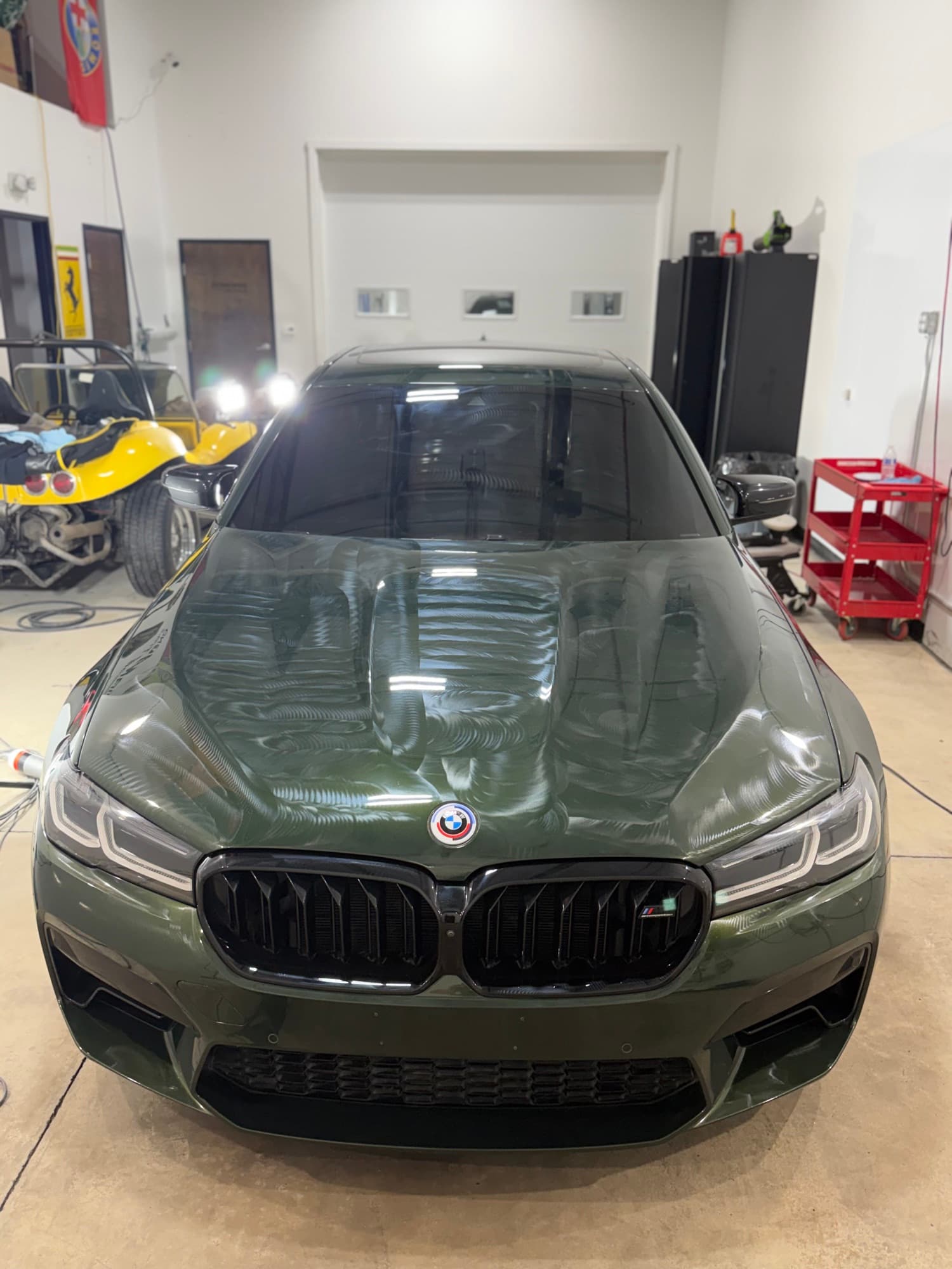 Military-green BMW M5 Competition front in the Diamond Detailz install bay